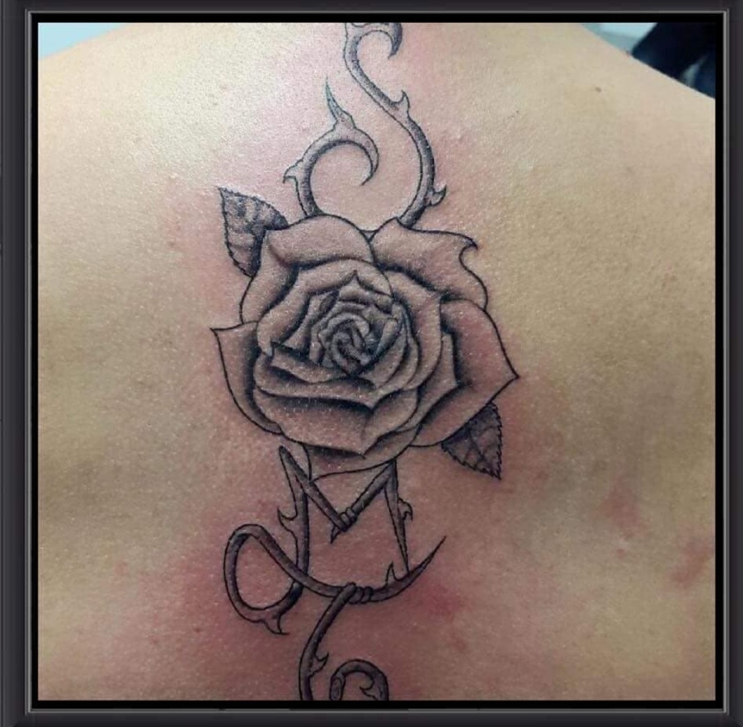 Tatouage rose et ronce en noir et gris